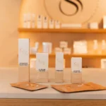 KRX Aesthetics producten op een verlicht rek voor de wand met het Sarkisian monogram