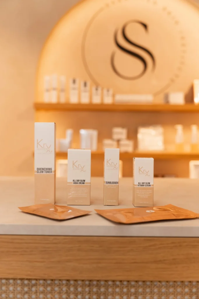 KRX Aesthetics producten op een verlicht rek voor de wand met het Sarkisian monogram