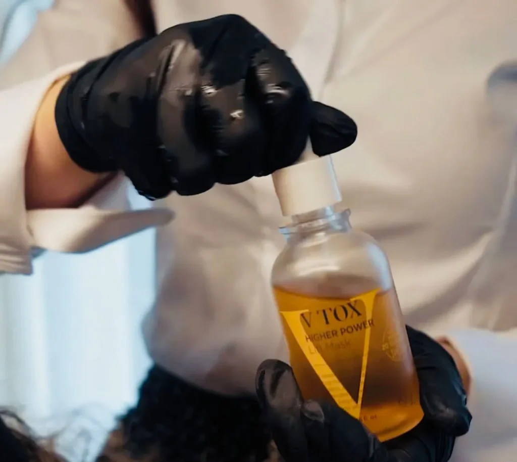 Flacon V-Tox van KRX in een gehandschoende hand, klaar voor de behandeling