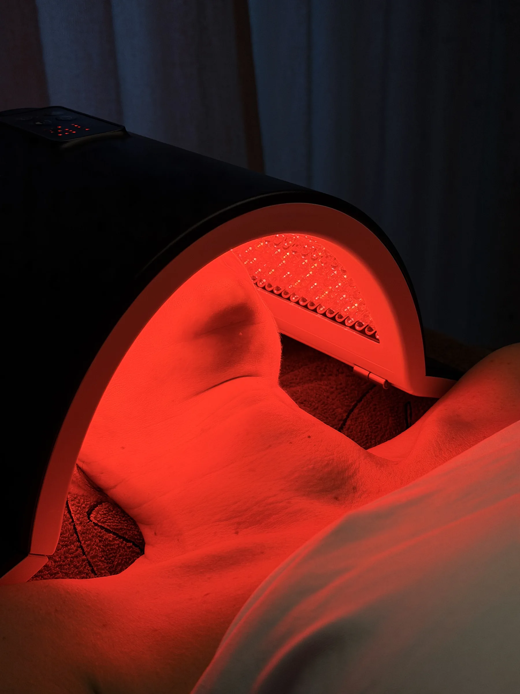 Rood licht van de LED-lamp op de kin en hals van een klant